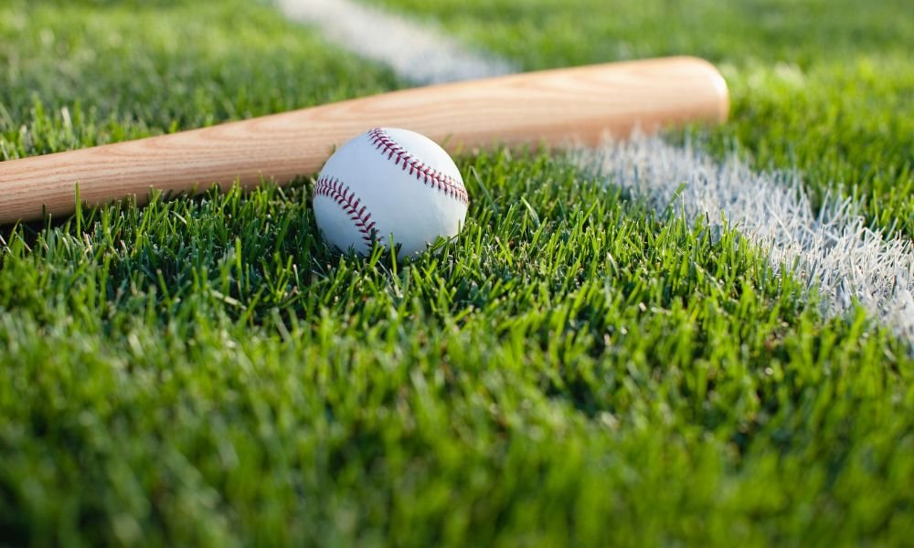 A baseball bat and ball on grass, a bat that is 33 inches long among things that are 33 inches long