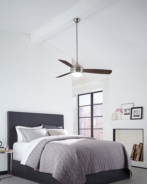 A ceiling fan above a bed in a bedroom, showing the blade sweep of things that are 42 inches long