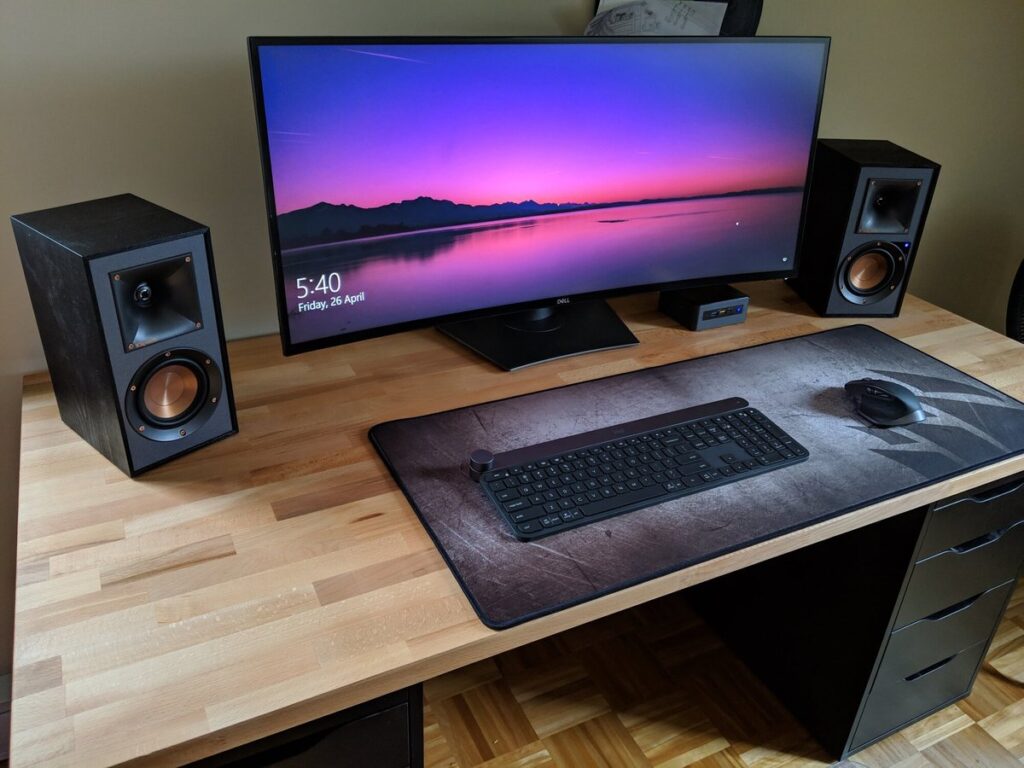 Computer desk setup with monitor and speakers among things that are 53 inches long