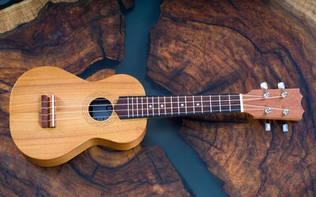 soprano ukulele about 21 inches long on a wooden table, a musical example of things that are 21 inches long