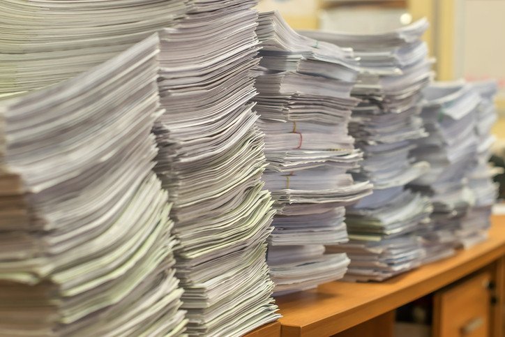 Stack of paper sheets and documents on a desk illustrating things that are 47 inches long