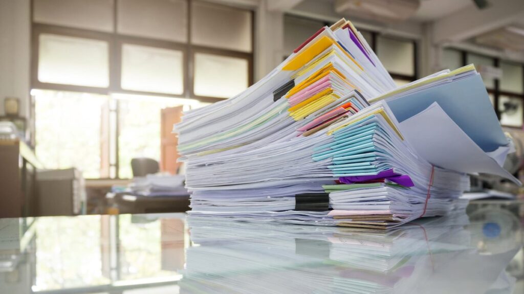 Stack of paper sheets and documents on a desk illustrating things that are 45 inches long